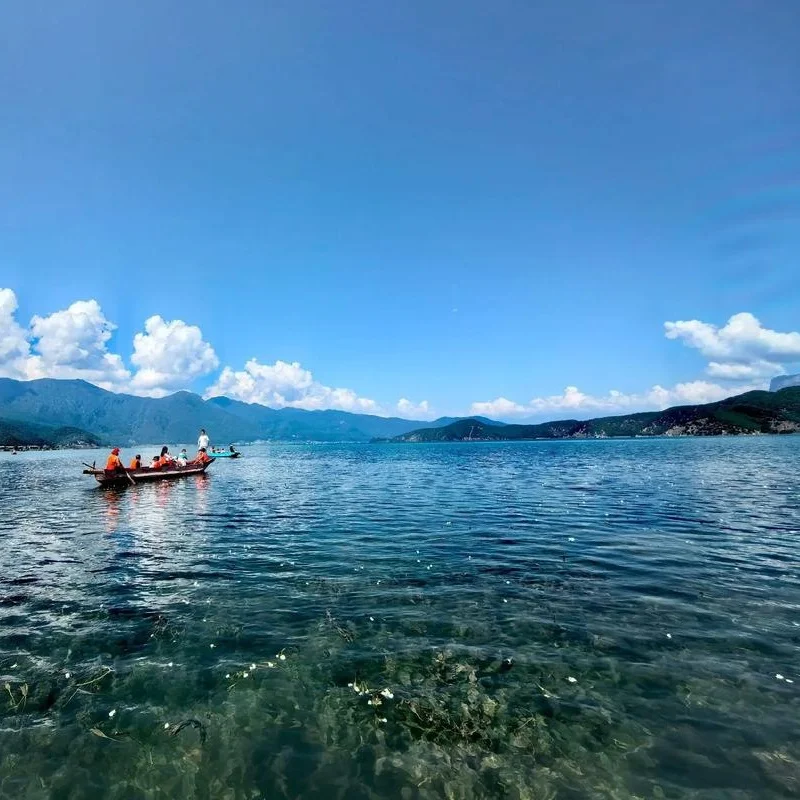 Lugu Lake pig trough boat 1 瀘沽湖的經典畫面:澄澈湖水、豬槽船與水面上的水性楊花,搭配藍天白雲與遠山,宛如人間仙境。