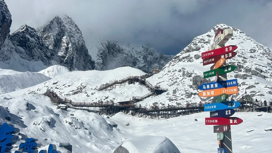 Jade Dragon Snow Mountain 1 麗江玉龍雪山 4506 高山觀景台,皚皚白雪覆蓋嶙峋雪峰,木棧道蜿蜒雪山之間,雲霧繚繞山巔,立有海內外城市距離指引牌。