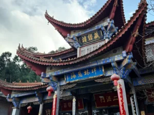 昆明西山華亭寺的藏經樓，飛檐翹角的傳統中式建築，彩繪樑柱與紅燈籠相映，是西山深處充滿禪意的古剎景點。